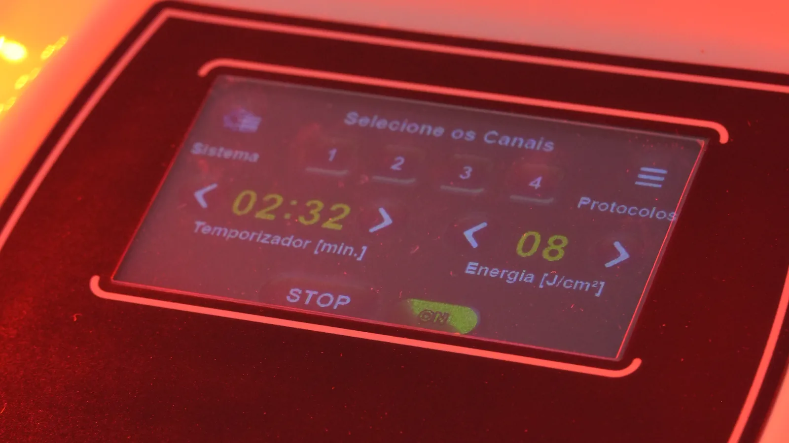 Tela sensível ao toque do LEDPLATTEN com seleção de canais, temporizador em minutos e energia em J/cm², sob a luz vermelha das placas